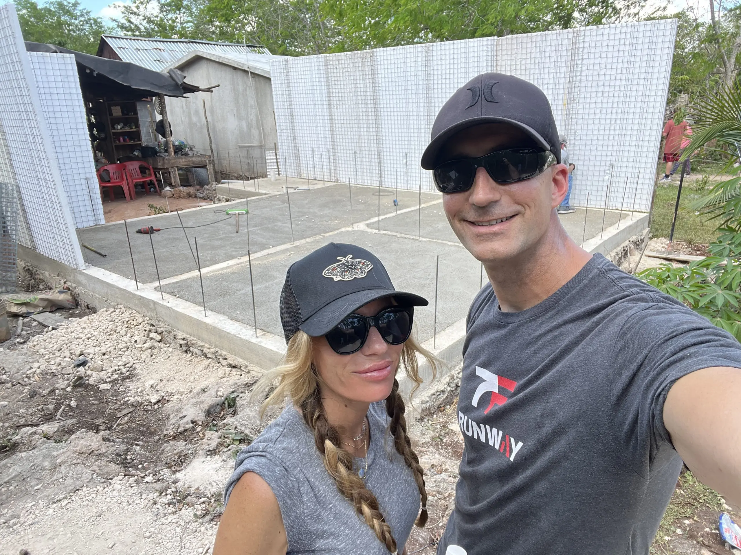 RealtyZoom owners visiting an active construction site with concrete foundation and foam block walls.